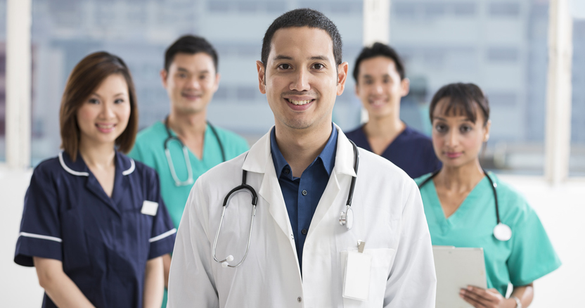 Group of doctors and nurses standing in a hospital. Multi-ethnic team of caucasian, Chinese and indian medical staff.